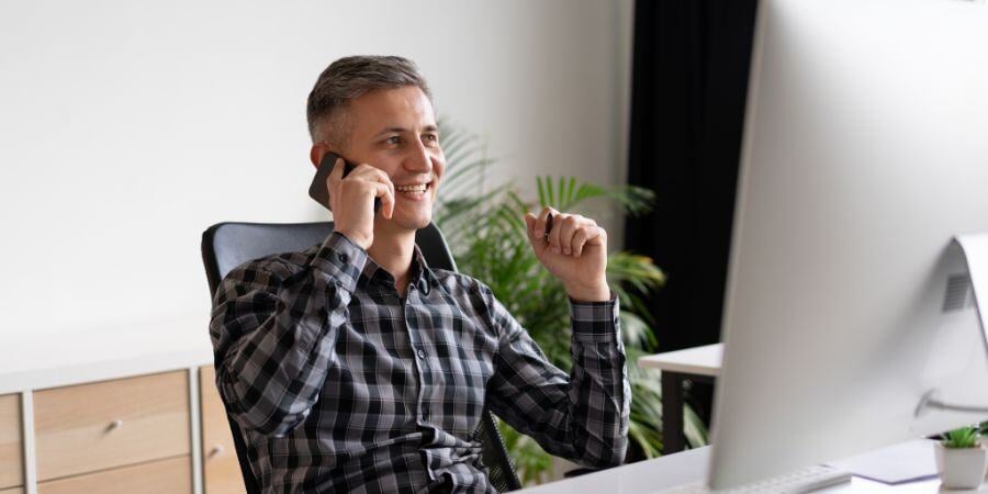 smiling man working from home office while talking